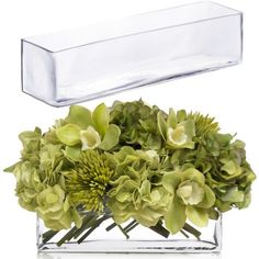 a clear vase filled with green flowers on top of a white table next to a glass box