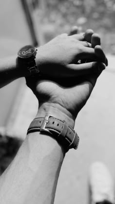 black and white photograph of two people holding each other's hand with both hands