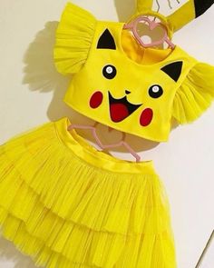 there is a yellow costume with a cat on it's head and two strings attached to the top