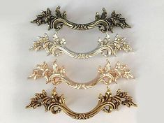 four antique brass drawer pulls on a white background