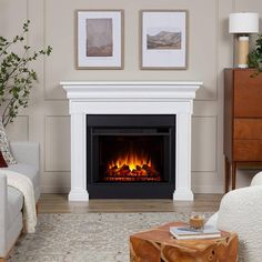 a living room with a fire place in the center and two pictures on the wall