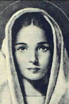 an old black and white photo of a woman with a hood over her head, looking at the camera