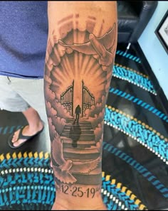 a person with a tattoo on their arm that has stairs leading up to a bridge