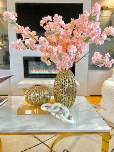 a vase with flowers on top of a table in front of a fire place and fireplace