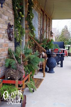 the front porch is decorated for christmas with greenery