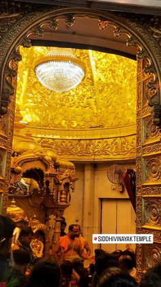 the inside of an ornately decorated building with people sitting in it and looking up at the ceiling