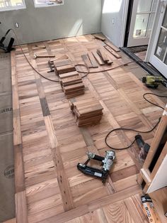 a room that is being remodeled with wood flooring and tools on the ground in front of it