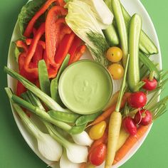 a white plate topped with lots of veggies and dip