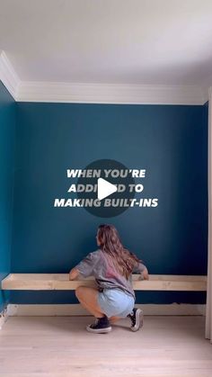 a woman sitting on a bench in front of a blue wall with the words when you're add to making buildings