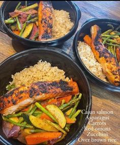 three black bowls filled with food on top of a wooden table next to rice and veggies