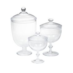 three clear glass containers with lids on each one and an empty bowl on the other