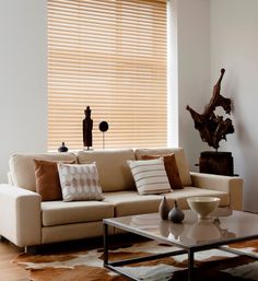 a living room filled with furniture and a large window covered in wooden slatted blinds