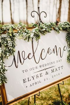 a welcome sign with greenery on it