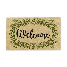 a welcome mat with the word welcome in black ink on it and green leaves around it