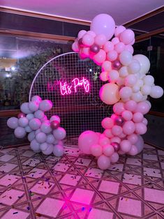 the balloon arch is decorated with pink and white balloons