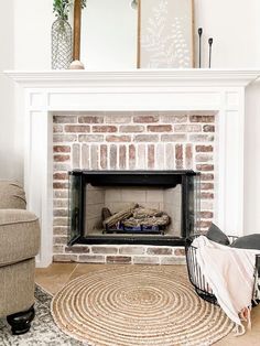 a living room with a fire place in the middle and a rug on the floor