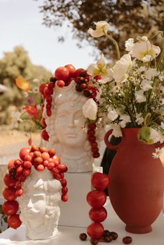 three vases with flowers in them sitting on a table next to each other,