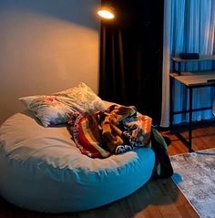 a large bean bag chair sitting on top of a wooden floor next to a window