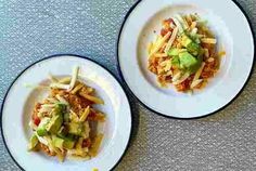 two white plates topped with food on top of a table