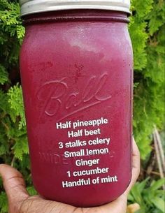 a hand holding a mason jar filled with purple liquid and instructions for how to use it