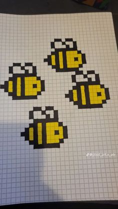 four yellow and black pixeles are on top of a sheet of paper with white squares