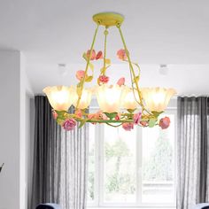 a chandelier hanging from the ceiling in a dining room with flowers on it