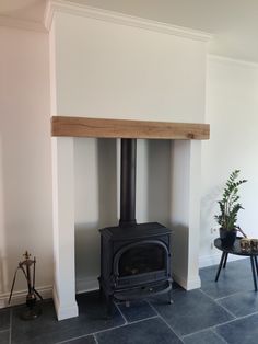 a wood burning stove sitting inside of a living room next to a potted plant