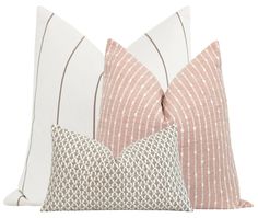 two pillows with different patterns on them, one in pink and the other in white