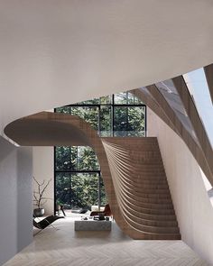 a woman is walking down the stairs in a modern house with large windows and an unusual staircase