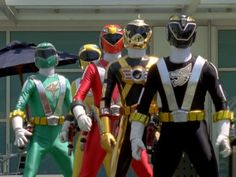 five power rangers standing in front of a building