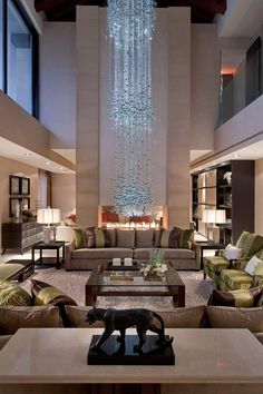 a living room filled with furniture and a large chandelier hanging from the ceiling