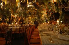 an elaborately decorated dining room with chandeliers and flowers hanging from the ceiling