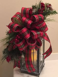 a lantern with a red and black plaid bow on it