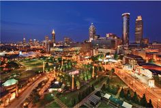 an aerial view of a city at night with tall buildings and lights on the streets