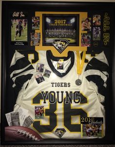 a football jersey is displayed in a shadow box with photos and memorabilia on the wall