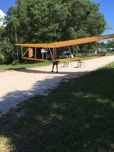 a man standing next to an airplane on top of a field