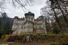 an old castle like building in the woods