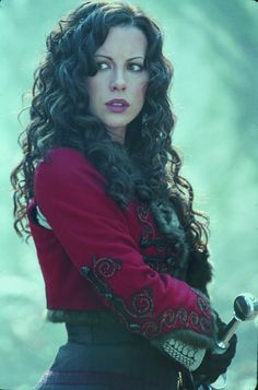 a woman with long curly hair wearing a red coat