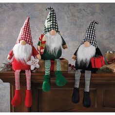 three christmas gnomes sitting on top of a table