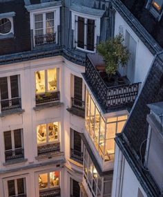 an apartment building with many windows and balconies lit up at night in the evening