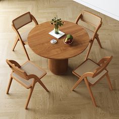 a wooden table with four chairs around it and a vase filled with flowers on top