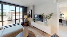 a living room filled with furniture and a flat screen tv on top of a wall