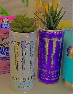 two cans with plants in them sitting next to each other on a counter top,