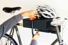 a person fixing a bicycle helmet on top of a rack