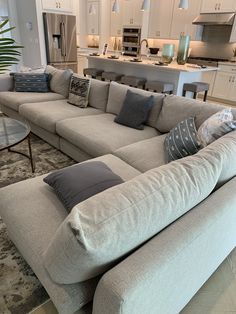 a living room filled with furniture next to a kitchen