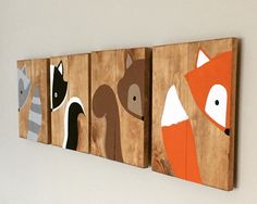 three wooden wall hangings with different animals painted on the sides of them, mounted to a white wall