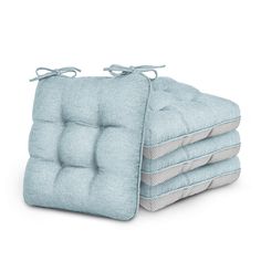 four blue cushions stacked on top of each other with ties around the edges, and one cushion