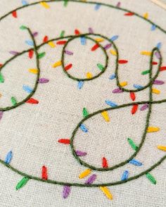 a close up of a embroidery on a piece of cloth with sprinkles