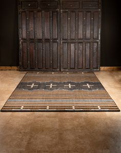 an old wooden door is next to a rug