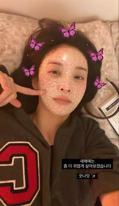 a woman laying on top of a bed covered in white glitter with butterflies above her head